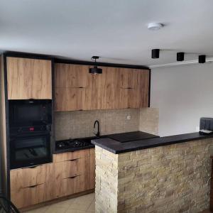 a kitchen with wooden cabinets and a stove top oven at Apartament Kościuszki in Sanok