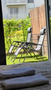 two chairs sitting on the grass outside a window at Green Terrace Family Apartment in Wrocław
