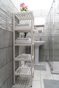 uma casa de banho com um lavatório e uma prateleira com toalhas em Casa vacanze La Dolce Casa em Catânia