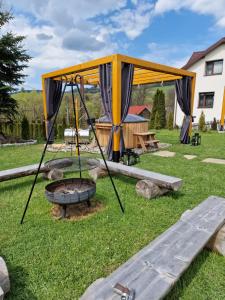 a tent and a fire pit in a yard at Domek na wypoczynek in Tylicz