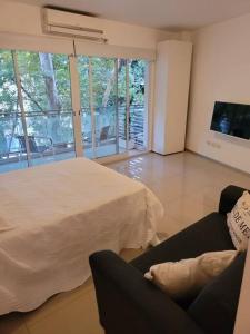 sala de estar con cama y sofá en Departamento nuevo a estrenar Cañitas-Palermo en Buenos Aires