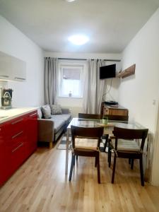 Il comprend une cuisine et un salon avec une table et des chaises. dans l'établissement APARTMÁNY za SNĚŽNÍKEM, à Dolní Morava