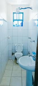 a white bathroom with a toilet and a sink at EuphGlory accomodations 1 and 2 bedrooms in Kakamega +26 photos