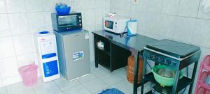 a kitchen with a counter with a microwave and a refrigerator at EuphGlory accomodations 1 and 2 bedrooms in Kakamega