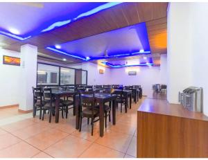 a dining room with tables and chairs and blue lights at Hotel Aerodyo Inn, Laxmeshwar in Almora