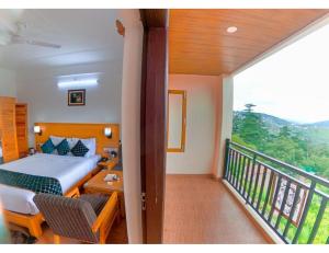 a bedroom with a bed and a balcony at Hotel Aerodyo Inn, Laxmeshwar in Almora