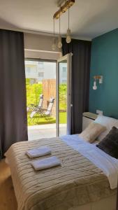 a bedroom with a large bed with two towels on it at Green Terrace Family Apartment in Wrocław