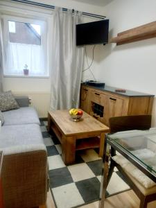 - un salon avec un canapé et une table dans l'établissement APARTMÁNY za SNĚŽNÍKEM, à Dolní Morava
