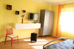 1 dormitorio con 1 cama, TV y silla en Hotel Na Vodách, en Mariánské Lázně