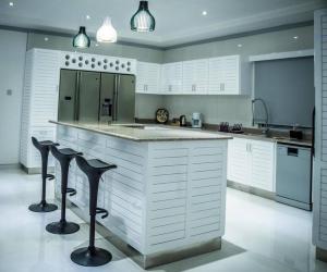 a kitchen with a large counter with stools in it at Island Charm of Praslin in Victoria