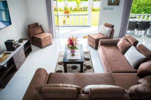 a living room with two couches and a table at Island Charm of Praslin in Victoria