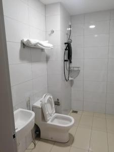 a white bathroom with a toilet and a sink at Amber Cove Chillax Homestay Melaka in Melaka