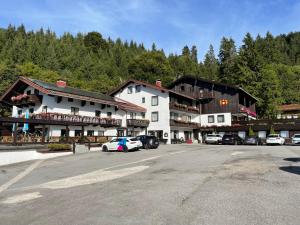 ein großes Gebäude mit Autos auf einem Parkplatz in der Unterkunft Hotel Gundl Alm in Schliersee