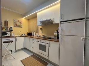 una cucina con mobili bianchi e un frigorifero di Apartment Covelo a Samieira Altre 43 foto
