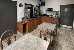 a restaurant with two tables and a counter with a kitchen at Days Inn by Wyndham Charlotte Northlake in Charlotte