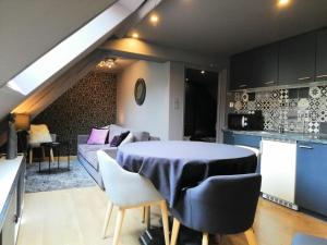 a kitchen and living room with a table and a couch at L'Escale Glamour et Chic - Netflix, Petit déjeuner français in Niederbronn-les-Bains +1 photo