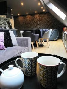 a living room with two coffee cups on a table at OFFRE SPECIALE JUIN - L'Escale Glamour et Chic - CROISEE DES PARCS - PETIT DEJEUNER, NETFLIX, WIFI in Niederbronn-les-Bains