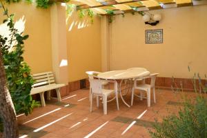 a patio with a table and chairs and a bench at Vespri Siciliani in Avola