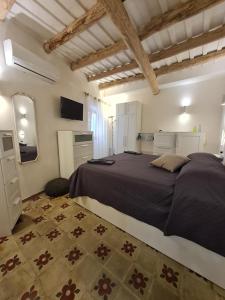 um quarto com uma cama grande e uma televisão em Tra i Mari em Trapani