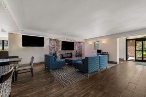 vestíbulo con sillas, mesas y chimenea en Quality Inn & Suites Airport en Charlotte