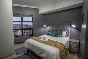 a bedroom with a large bed with a large window at Stay at The Point - Arabian Affair in Durban