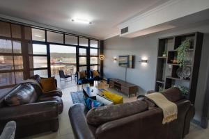 una sala de estar con 2 sofás de cuero y una sala de estar con en Stay at The Point - Arabian Affair, en Durban