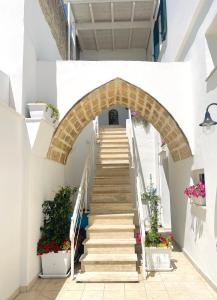 una escalera que conduce a un edificio con flores en Finestra sul Borgo Apt., en Acquarica del Capo