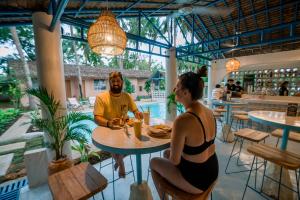 un homme et une femme assis à une table dans un restaurant dans l'établissement Mad Monkey Panglao, à Panglao