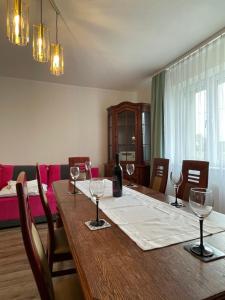 Apartament NaKaszubach في Szemud: غرفة طعام مع طاولة مع كؤوس للنبيذ