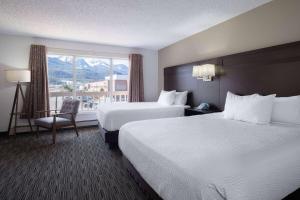 a hotel room with two beds and a window at Ramada by Wyndham Juneau in Juneau