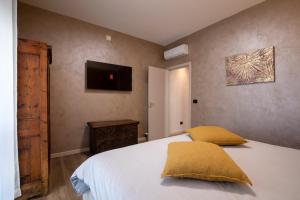 Un dormitorio con una cama y un televisor en la pared. en LA LUPA Apartment - In the heart of Aosta with car Box, en Aosta