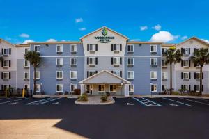 un grande hotel con un parcheggio di fronte di WoodSpring Suites Orlando West - Clermont a Clermont