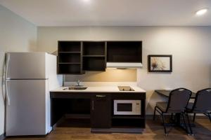 a kitchen with a refrigerator and a table and chairs at WoodSpring Suites Orlando West - Clermont in Clermont