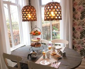 uma sala de jantar com uma mesa de madeira e duas luzes em B&B het Klontje em Vriescheloo