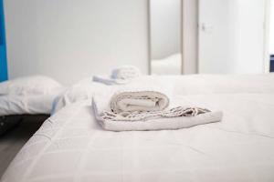 a white towel sitting on top of a bed at Haarlem Square House City Centre Haarlem in Haarlem