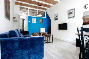 a living room with a blue couch and a tv at Haarlem Square House City Centre Haarlem in Haarlem