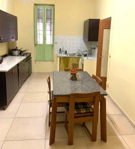 uma cozinha com uma mesa e cadeiras e uma cozinha com uma porta verde em Rustic cottage in Montalbano jonico em Montalbano Ionico