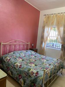 um quarto com uma cama com colcha floral em Rustic cottage in Montalbano jonico em Montalbano Ionico