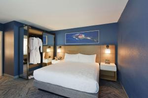 Cette chambre d'hôtel dispose d'un grand lit et de murs bleus. dans l'établissement Hyatt Centric Santa Clara Silicon Valley, à Santa Clara