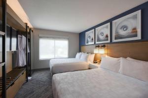 聖克拉拉的住宿－廣場套房酒店，酒店客房设有两张床和窗户。