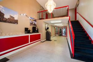 eine Lobby mit einer Treppe und einem roten Geländer in der Unterkunft Rodeway Inn in Columbia