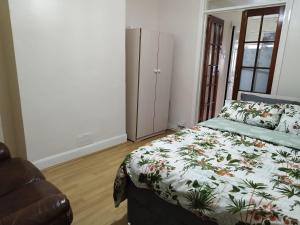 a bedroom with a bed and a chair in it at Nice Studio Flat in Edmonton, North London in Edmonton