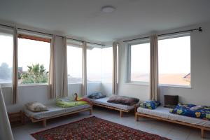 a room with two beds and large windows at רוג'ום גסטהאוס Rujum in Arad