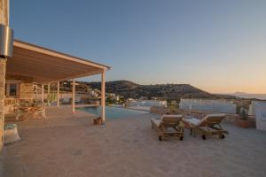 een patio met 2 stoelen en een zwembad bij VILLA LEVANTA - Das ideale Wohlfühl-Refugium Aussicht, Komfort, Erholen, Home Office in Pitsidia