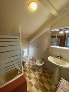 HOTEL ST SEBASTIEN في روكيوبيلير: حمام مع مرحاضين ومغسلة ودش