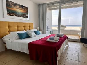 um quarto com uma cama grande e vista para a praia em Calatabarca B&B em Tabarca