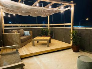 a patio with a couch and a table on a balcony at パプリカホテルです in Kisarazu