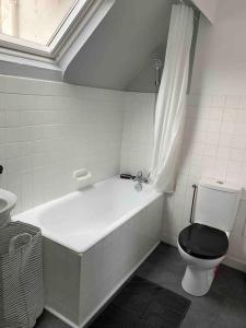 a bathroom with a tub and a toilet and a sink at Duplex sur le port du Croisic in Le Croisic