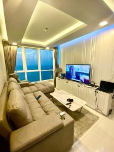 een woonkamer met een grote bank en een televisie bij LuxSL LuxuryStyleofLife 4 in Pattaya