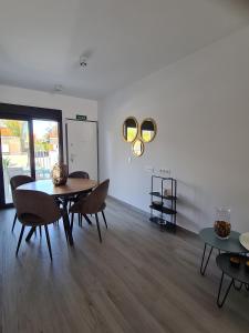 a dining room with a table and chairs and a white wall at Luxe nieuwbouw appartement op 50m van de zee in San Javier